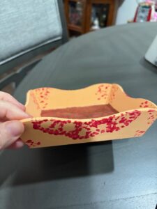 square, yellow dish with red lacey design